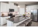 Bright kitchen featuring stainless steel appliances, granite counters, white cabinets and a central island at 1556 Covey Rise Ter, Winter Haven, FL 33884