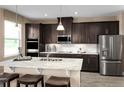 Modern kitchen featuring stainless steel appliances, granite countertops, and dark wood cabinets at 3190 Tiger Palm Way, New Smyrna Beach, FL 32168