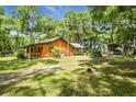 Scenic log cabin showcasing a covered porch, lush lawn, and convenient car port at 2955 Se 156Th Place Rd, Summerfield, FL 34491