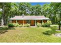 Inviting cabin with a covered porch and well-maintained landscaping at 2955 Se 156Th Place Rd, Summerfield, FL 34491