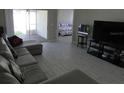 Comfortable living room featuring tile floors, neutral paint, and a sliding door leading to the outdoor area at 3806 Osprey Pointe Cir, Winter Haven, FL 33884