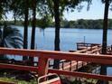 Scenic view of the lake from the wood deck, surrounded by lush trees creating a peaceful atmosphere at 3806 Osprey Pointe Cir, Winter Haven, FL 33884