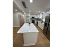 Bright, updated kitchen featuring white cabinets, stainless steel appliances, and a center island at 601 Lantern Ln, Orange City, FL 32763