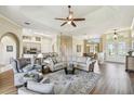 Open-concept living area with hardwood flooring, ceiling fan, and seamless flow into the dining and kitchen spaces at 27223 Nostalgia Dr, Leesburg, FL 34748