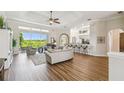 Spacious living room with hardwood floors, large windows, and an open layout, ideal for entertaining guests at 27223 Nostalgia Dr, Leesburg, FL 34748