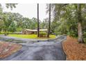 Exterior home view with long driveway, showcasing lush landscaping and ample parking space at 3341 Se 45Th St, Ocala, FL 34480