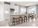 Stylish kitchen with white cabinetry, a center island with seating, and an adjacent dining area with lots of light at 1278 Whispering Ln, Minneola, FL 34715