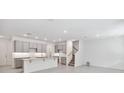 Open-concept kitchen with gray cabinetry, granite counters, and access to the staircase at 5236 Luisa Ct, St Cloud, FL 34771