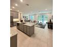 Open-concept living space with a large kitchen island and sliding glass doors to the backyard at 5236 Luisa Ct, St Cloud, FL 34771