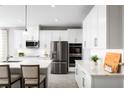 Modern kitchen with white cabinets, stainless steel appliances, and a large island with seating at 11033 Nellie Crossing Cir, Clermont, FL 34711
