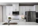 Elegant kitchen featuring stainless steel appliances, white cabinetry, and a stylish backsplash for a modern feel at 11033 Nellie Crossing Cir, Clermont, FL 34711
