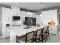 Bright kitchen featuring an island with seating, stainless appliances, and white cabinets, perfect for entertaining at 11033 Nellie Crossing Cir, Clermont, FL 34711