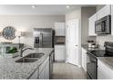 Modern kitchen with stainless steel appliances, granite countertops, and white cabinetry at 1538 Landon Ln, Haines City, FL 33844