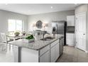 Open kitchen boasts granite countertops, stainless steel appliances, and a view into the dining area at 1538 Landon Ln, Haines City, FL 33844