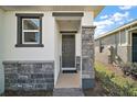Inviting front entrance with stone accents, neutral door, and manicured landscaping at 4106 Nw 44 Cir, Ocala, FL 34482