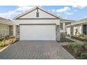 Spacious two-car garage with a brick-paved driveway and manicured landscaping at 4106 Nw 44 Cir, Ocala, FL 34482