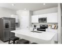 Bright kitchen featuring white cabinets, stainless steel appliances, and a spacious quartz countertop island at 420 Harvard Ct, Dundee, FL 33838