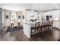 Modern kitchen features a granite-top island with seating, stainless steel appliances, and white cabinetry at 480 Crossings Ave, St Cloud, FL 34771