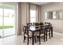 Elegant dining area with stylish furniture and a sliding glass door to the backyard at 5739 Anders Way, St Cloud, FL 34771