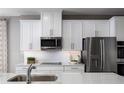 Bright modern kitchen featuring white cabinets, stainless steel appliances, and sleek countertops at 5739 Anders Way, St Cloud, FL 34771