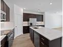 Modern kitchen with stainless steel appliances, a large island, and dark cabinets at 1126 Desert Candle Dr, Ocoee, FL 34761