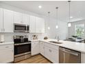 Modern kitchen with stainless steel appliances, white cabinets, and quartz countertops, ideal for cooking and entertaining at 3307 Grande Heron Dr, St Cloud, FL 34773