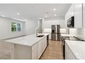 A bright kitchen with white cabinetry, stainless steel appliances, and a large island with a sink at 5240 Luisa Ct, St Cloud, FL 34771