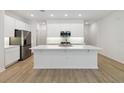 A modern, all white kitchen with a large island and stainless steel appliances at 5240 Luisa Ct, St Cloud, FL 34771