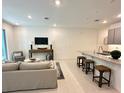 Inviting living room is complete with stylish furniture, modern lighting, and flows into the open kitchen area at 5240 Luisa Ct, St Cloud, FL 34771