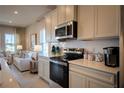 Modern kitchen with stainless steel appliances, white cabinetry, and stylish backsplash at 554 Highfalls Ave, Debary, FL 32713