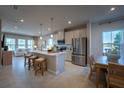 Open-concept kitchen featuring a center island, stainless steel appliances, and seamless integration with dining and living areas at 554 Highfalls Ave, Debary, FL 32713