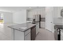 Kitchen boasts stainless steel appliances, granite countertops and white cabinets at 1130 Desert Candle Dr, Ocoee, FL 34761