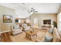 Cozy living room with hardwood floors, neutral paint, comfortable seating, and an open layout leading into the kitchen at 1161 Cr 443, Lake Panasoffkee, FL 33538