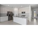 Modern kitchen features white cabinetry, stainless appliances, granite counters, and a kitchen island at 1096 Desert Candle Dr, Ocoee, FL 34761