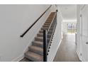 Carpeted staircase featuring wood handrail and black metal spindles at 1096 Desert Candle Dr, Ocoee, FL 34761