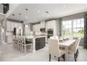 Modern kitchen features stainless steel appliances, island with bar seating, and white cabinetry at 136 Venetian Palms Blvd, New Smyrna Beach, FL 32168