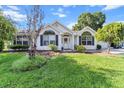Charming white brick home with manicured landscaping and large arched windows at 8596 Sw 108Th Place Rd, Ocala, FL 34481