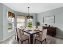 Elegant dining room featuring neutral wall paint and a large square table for six at 1424 Figueroa St, The Villages, FL 32162