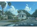 Community's gatehouse, offering controlled access with a visitor's entrance, an American flag, and lush tropical landscaping at 1424 Figueroa St, The Villages, FL 32162