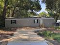 Classic home featuring a manicured lawn, neutral siding, and welcoming front entrance at 3346 Se 131St Pl, Belleview, FL 34420