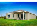 Expansive backyard featuring a covered patio with outdoor seating, ideal for relaxation and entertaining at 454 Hammock Oaks Blvd, Lady Lake, FL 32159