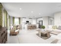 Open-concept living space with a large island, stainless steel appliances, and stylish furniture at 454 Hammock Oaks Blvd, Lady Lake, FL 32159