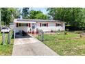 Charming single-story home with red shutters, solar panels, a carport, and fenced front yard at 801 Nw 16Th Ct, Ocala, FL 34475
