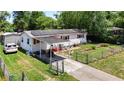 Charming single-story home with red shutters, solar panels, a carport, and fenced front yard at 801 Nw 16Th Ct, Ocala, FL 34475