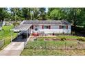 Charming single-story home with red shutters, solar panels, a carport, and fenced front yard at 801 Nw 16Th Ct, Ocala, FL 34475