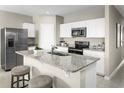 Well-equipped kitchen featuring a breakfast bar, stainless steel appliances, and granite countertops at 1389 Laramie Way, Haines City, FL 33844