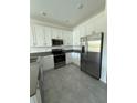 Well-lit kitchen with stainless steel appliances and ample storage in white cabinets at 7433 Stone Creek Trl, Kissimmee, FL 34747