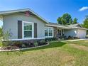 Beautifully landscaped yard surrounding a well-maintained home with stone detailing and inviting curb appeal at 12396 Sw 64Th Street Rd, Ocala, FL 34481