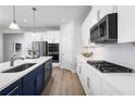 Modern kitchen featuring stainless steel appliances, white cabinets, quartz countertops and hardwood floors at 1524 Covey Rise Ter, Winter Haven, FL 33884
