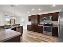 Modern kitchen with stainless steel appliances, wood cabinets, and a breakfast bar at 3315 Dzuro Dr, Oxford, FL 34484
